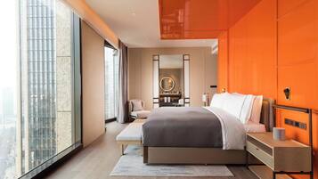 A modern bedroom with a large bed, a bedside table, a chair, a desk, and a large window.