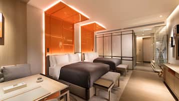 Una habitación de hotel moderna con una cama grande, un escritorio y una zona de estar.