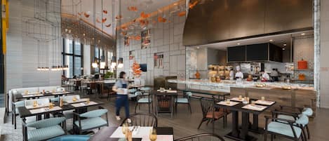 A modern restaurant with multiple dining areas, a kitchen, and a bar.