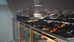 A nighttime cityscape with a prominent high-rise building in the center. - Mercu Summer Suite KLCC by Fervent (Kuala Lumpur)