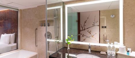 Une salle de bain moderne avec un grand miroir, un lavabo et une douche à l’italienne.