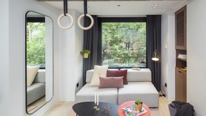 A modern living room with a grey sofa, a black coffee table, and a large window with curtains. - Stey Wangfujing (Beijing)