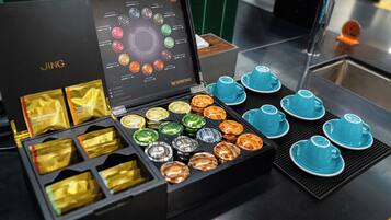 Una exhibición de diversas cápsulas Nespresso y tazas de café azules sobre una encimera.