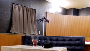 Una habitación moderna con un sofá de cuero negro, una mesa de mármol y suelo de madera.