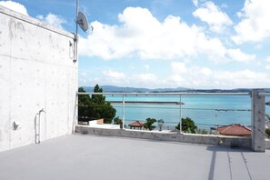 Une terrasse sur le toit offrant une vue dégagée sur une étendue d’eau et sur des montagnes lointaines.