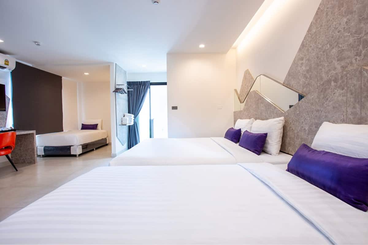 A modern hotel room with a large bed, a desk, and a shower area.