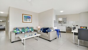 Una sala moderna con un sofá, una mesa de centro y un comedor con una mesa y sillas.