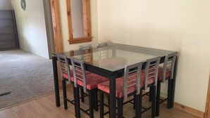 A dining area with a glass-top table and six chairs with red cushions. - Panoramic view ranch house near Crater Lake (Chiloquin)