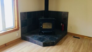 A room with a fireplace, a window, and a fire extinguisher. - Panoramic view ranch house near Crater Lake (Chiloquin)