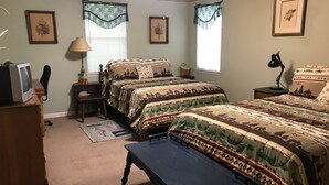 A bedroom with two beds, a desk, a chair, a television, and framed pictures on the walls. - Melody's Bed and "Catch Your Breakfast!" (Crockett)