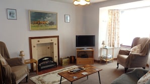 A living room with a fireplace, a television, and a sofa.