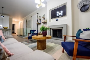 Relax in a spacious living room with a large flat-screen TV, cozy fireplace, and comfortable seating area.