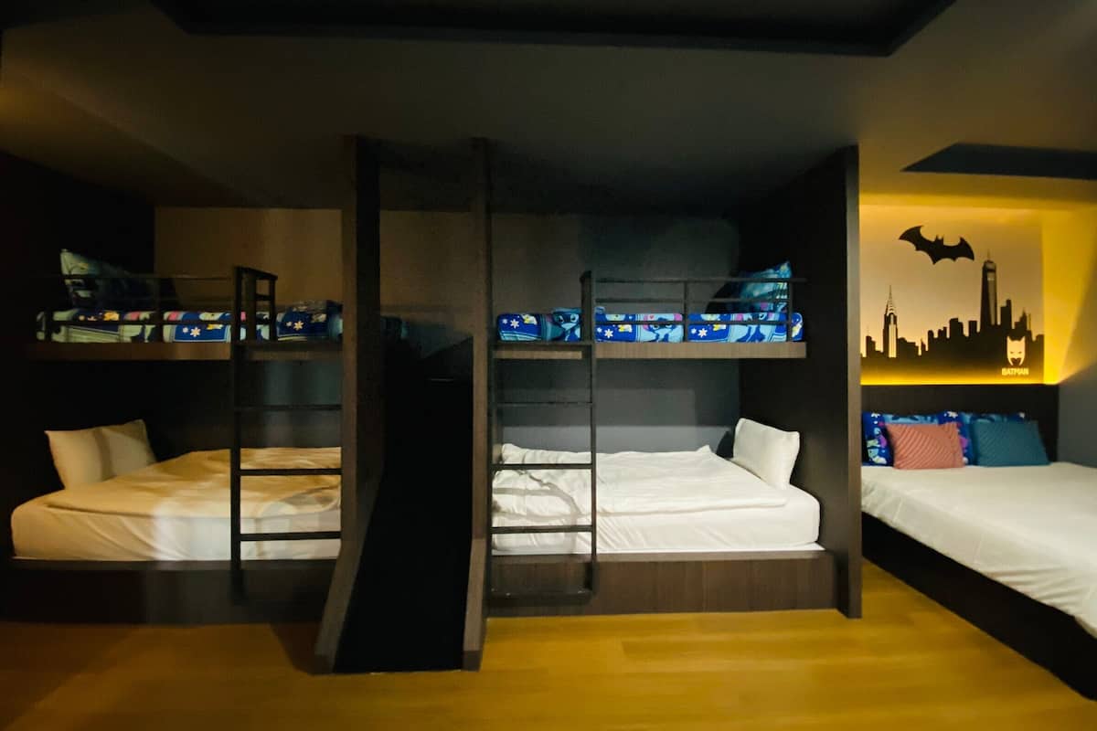 A room with bunk beds, a city skyline mural, and a Batman logo.