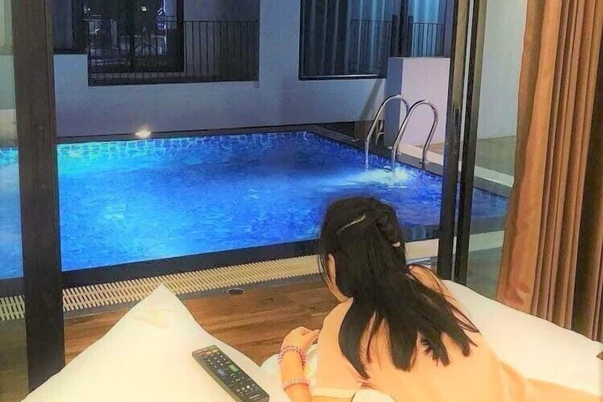 A room with a large window overlooking a swimming pool.