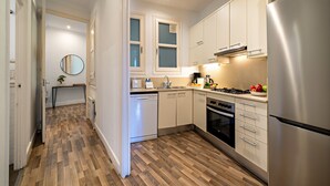 A modern kitchen with stainless steel appliances, white cabinetry, and a wooden floor. - Barcelona Balconies 1 - Habitat Apartments (Barcelona)