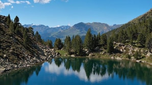 Un lac paisible, entouré de montagnes et d’une forêt dense.