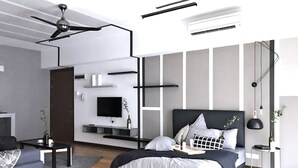 Quarto moderno com uma cama grande, TV fixada na parede e ventilador de teto.