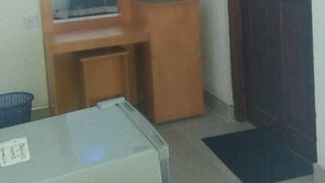 A room with a wooden desk, a mirror, a shelf with items, and a door. - Zircon Ella (Ella)