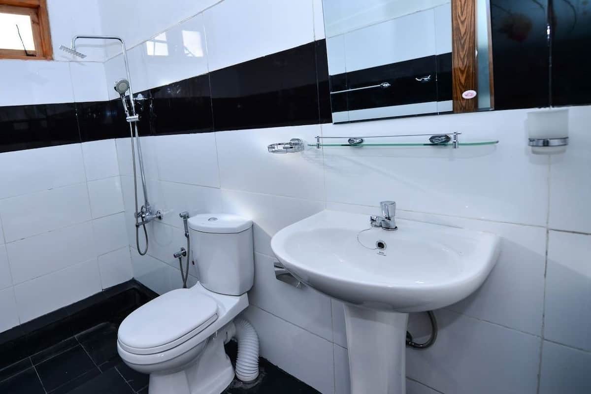 Un baño moderno con inodoro, lavabo y ducha.