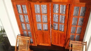 A wooden double door with glass panels and a brass handle. - Zircon Ella (Ella)