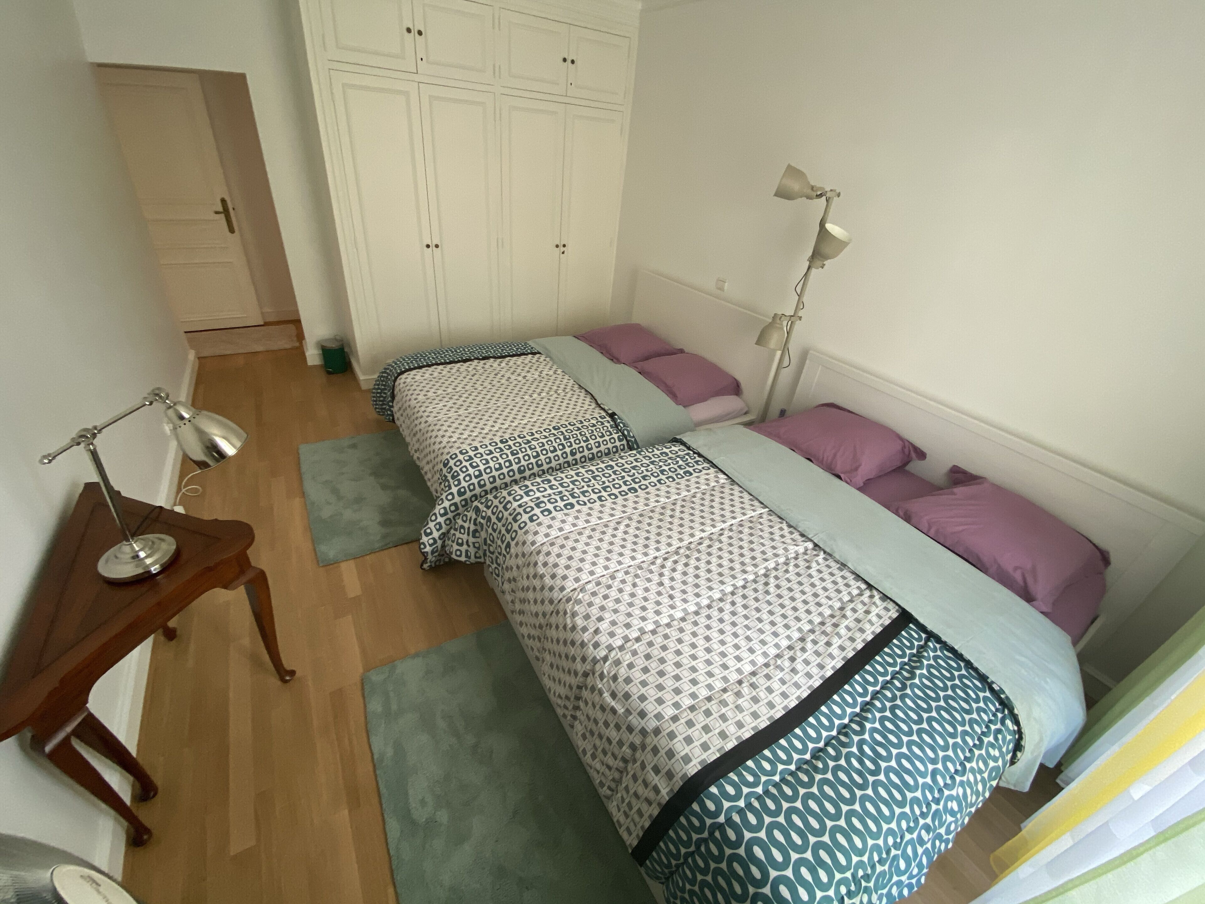 Une chambre avec deux lits, un bureau et une armoire.