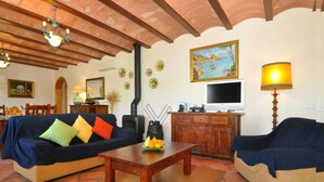 A cozy living room with two sofas, a wooden coffee table, a TV, and a fireplace. - Can Mostatxet, Country House in Can Picafort, Mallorca (Can Picafort)