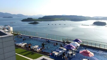 室外游泳池，池畔遮阳伞，日光浴躺椅