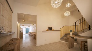 A modern interior with a staircase, wooden flooring, and a dining area with chairs and a table.