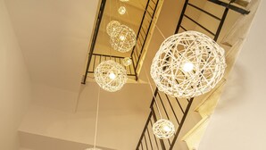 A staircase with a glass railing and decorative spherical light fixtures.