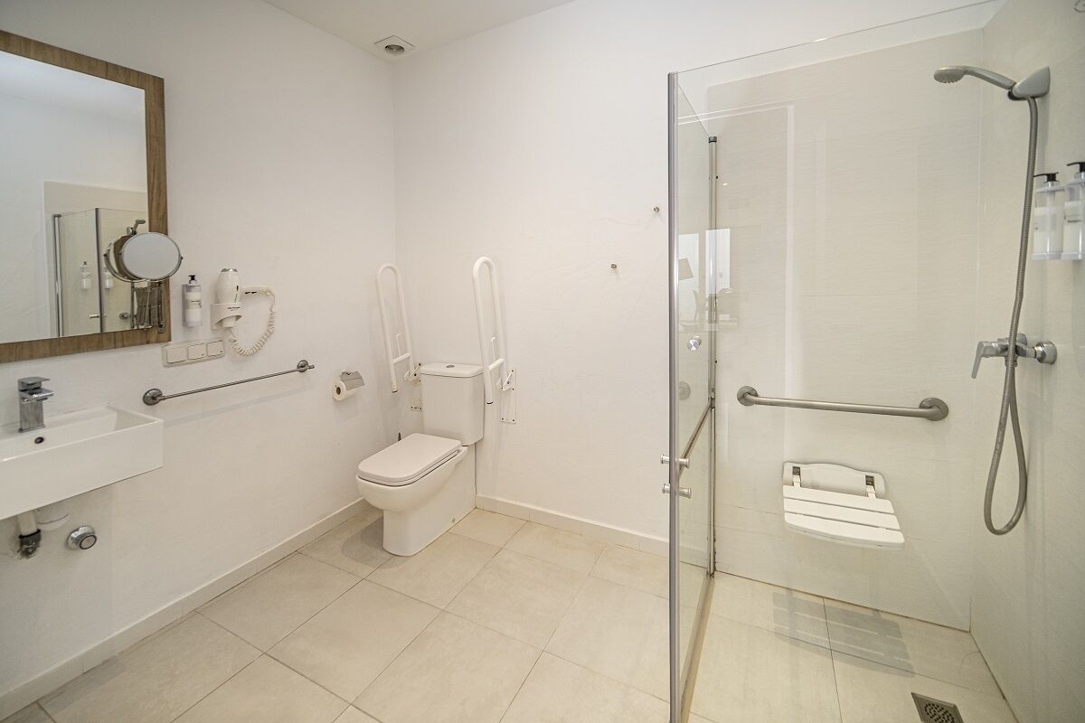 Une salle de bain moderne avec une douche à parois de verre, des toilettes, un lavabo et un miroir.