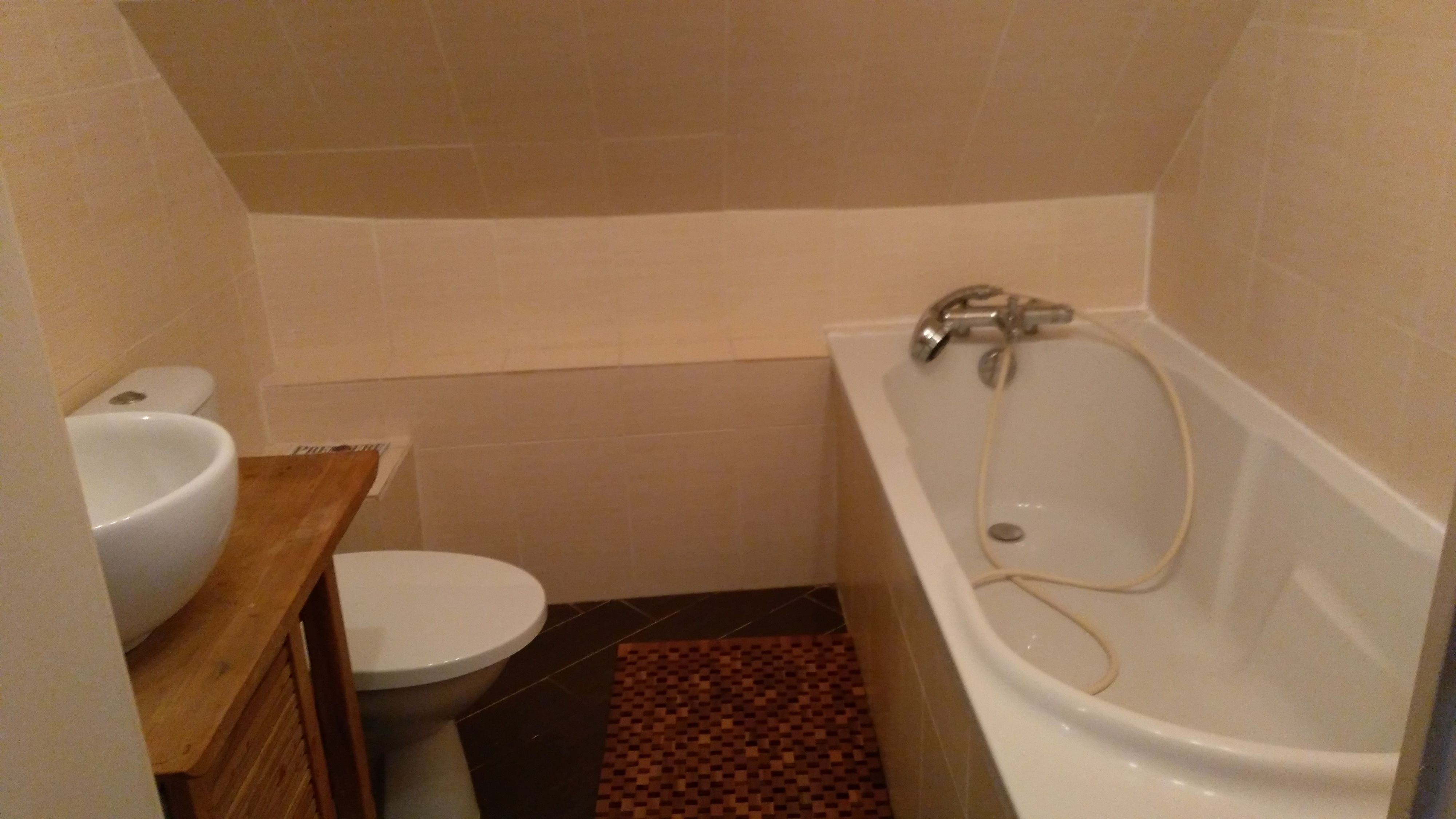 Ein kleines Badezimmer mit Toilette, Waschbecken und Badewanne.