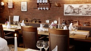 A restaurant with brick walls, wooden tables, and chairs.