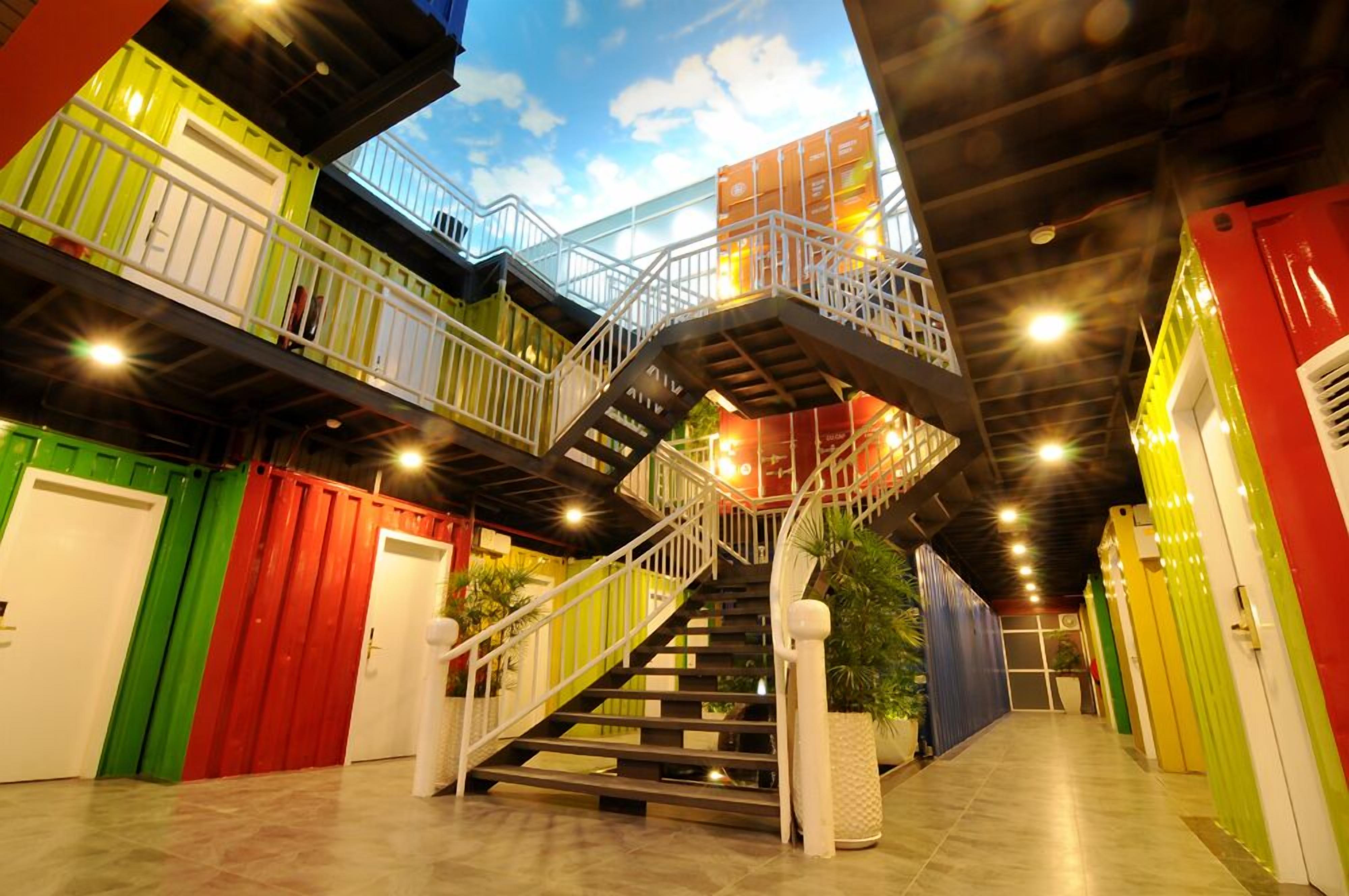 A multi-level indoor space with a staircase connecting different areas, surrounded by colorful walls and railings.