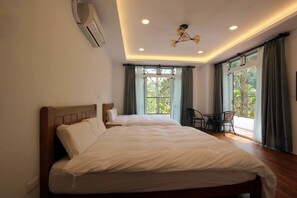 A bedroom with two beds, a ceiling fan, an air conditioning unit, and a balcony with a chair. - Song Yue Bed & Breakfast (Yuchi)