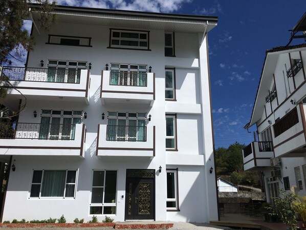 A multi-story building with balconies, windows, and a door. - Song Yue Bed & Breakfast (Yuchi)