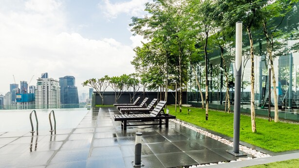 A rooftop terrace with lounge chairs, a glass railing, and a view of the city skyline. - Dorsett Residences Bukit Bintang - Sweet Home KL (Kuala Lumpur)