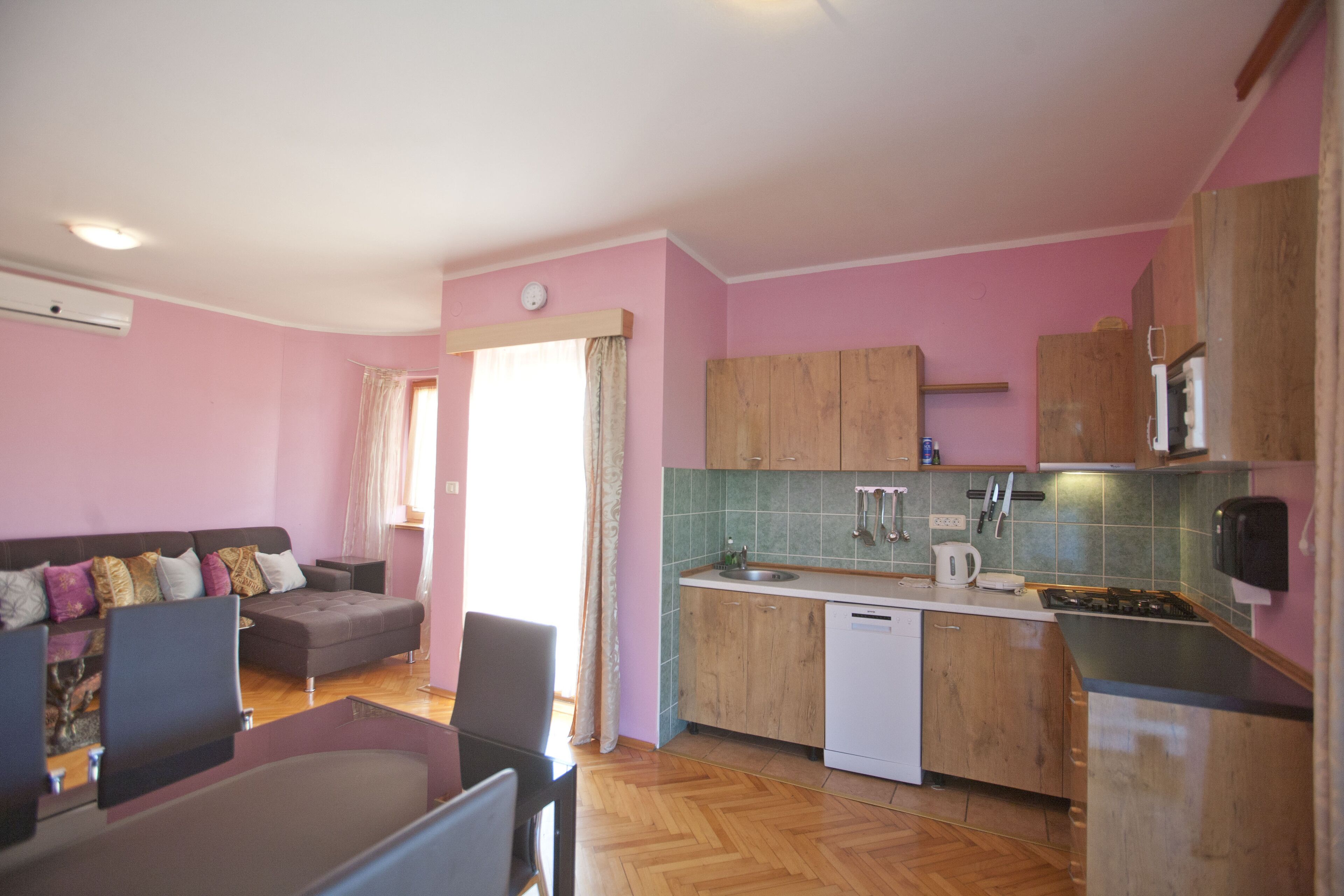 Un espacio habitable compacto con kitchenette, un sofá, una mesa de comedor y una silla.