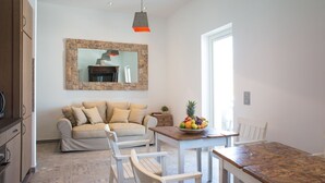 Uma cozinha moderna com uma mesa e cadeiras de madeira, uma fruteira e um espelho grande na parede.