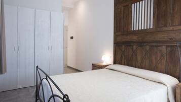 Ein Schlafzimmer mit einem Bett, einem Kleiderschrank und einem Nachttisch mit einer Lampe.