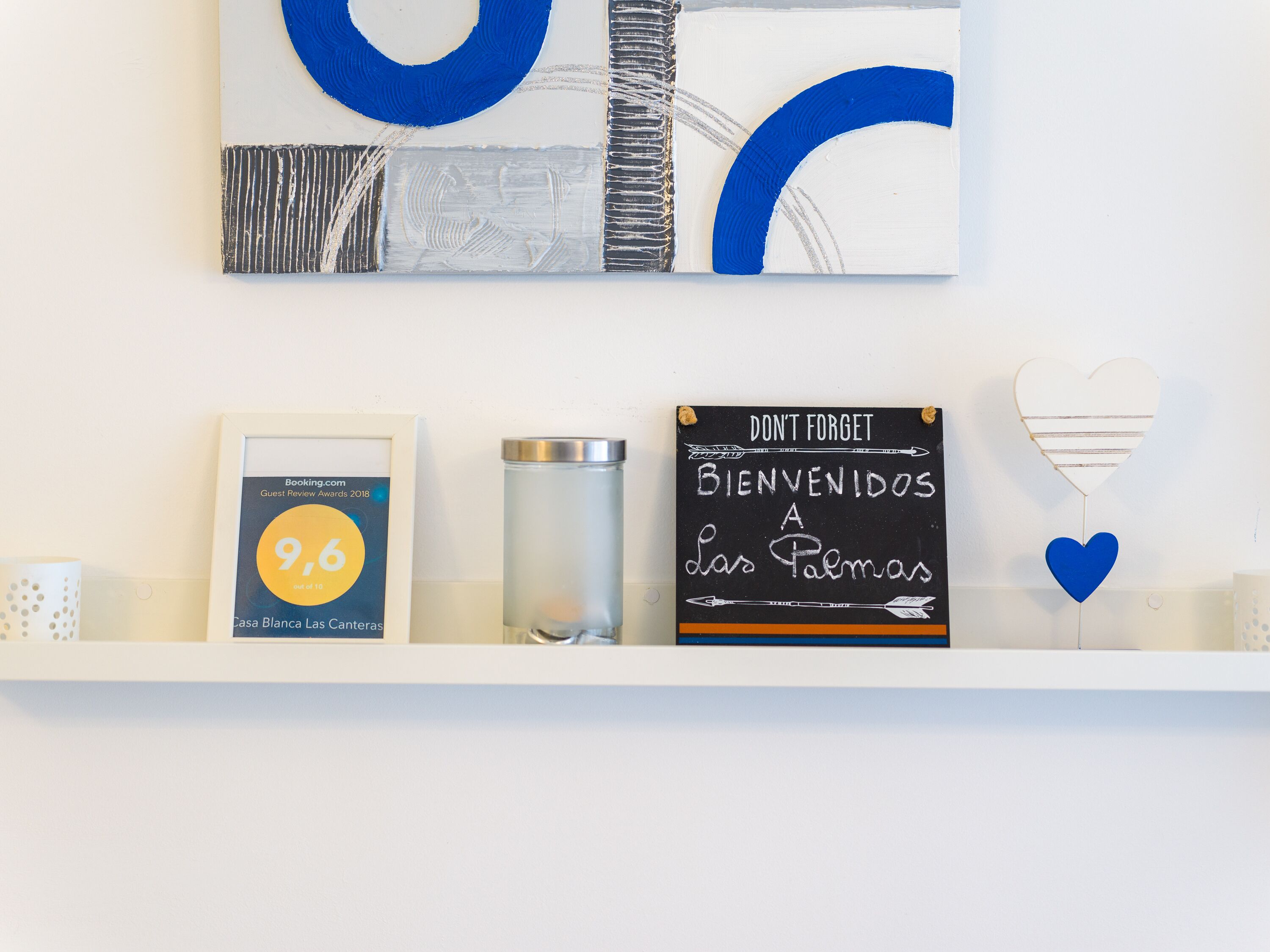 A wall with a framed certificate, a water bottle, a chalkboard sign, and a heart-shaped balloon.