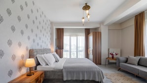 A modern bedroom with a bed, bedside table, and a sofa. - LP Lagun Palas (Altinova)