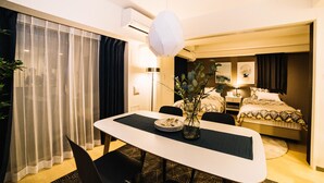Quarto de hotel com área de refeições, cama e banheiro.
