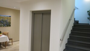 A staircase with a handrail, a door, and a painting on the wall. - Landgasthaus Stärk-Berding (Steinfeld)