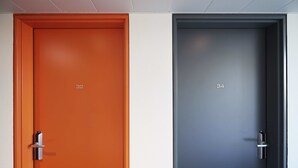 Two doors, one orange and one gray, with numbers 32 and 34 respectively. - Le Nex2 (Tarbes)