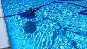 Ein Swimmingpool mit klarem, blauem Wasser, einer sichtbaren Poolleiter und einem Schwimmreifen.
