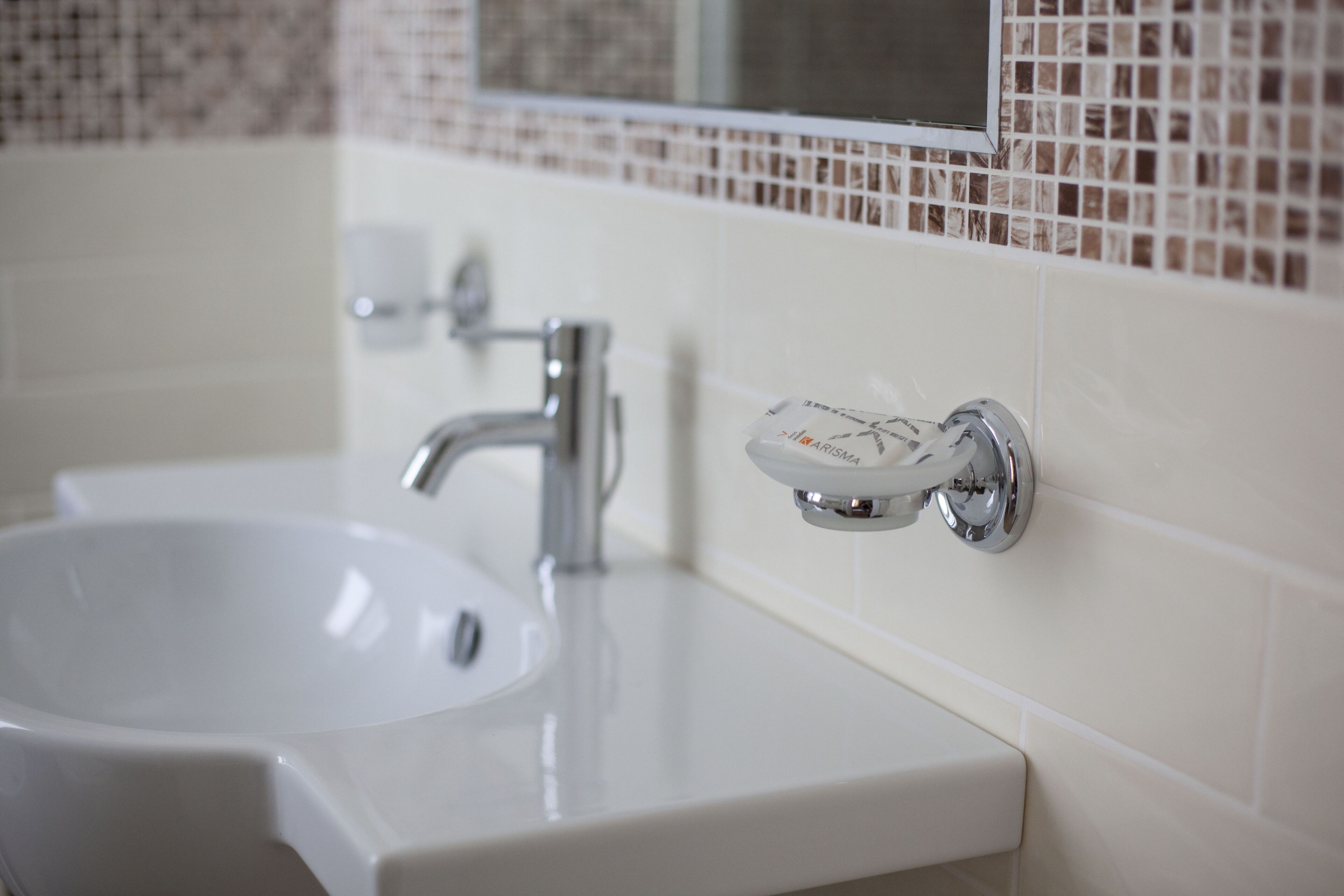 A bathroom sink with a chrome faucet and a soap dish.