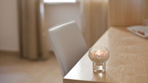 Een houten tafel met een glazen schaal waarin kaarsen en kleine voorwerpen liggen.