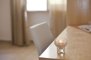 A wooden table with a clear glass bowl containing candles and small items.
