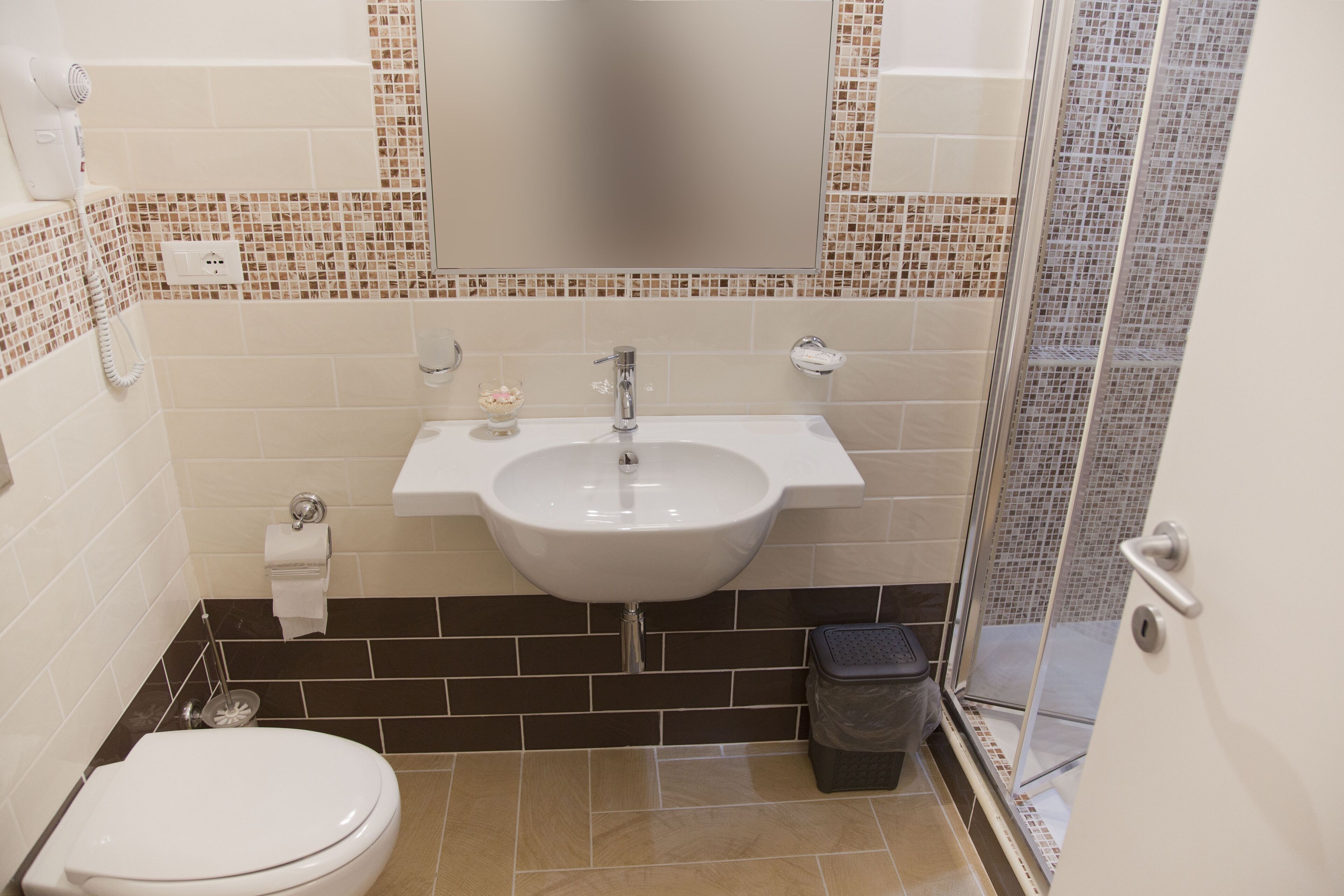 A bathroom with a white sink, a toilet, and a shower area.