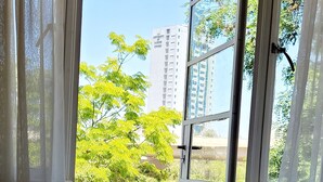 A room with a view of a balcony, a chair, and a window with curtains. - United Kenya Club (Nairobi)